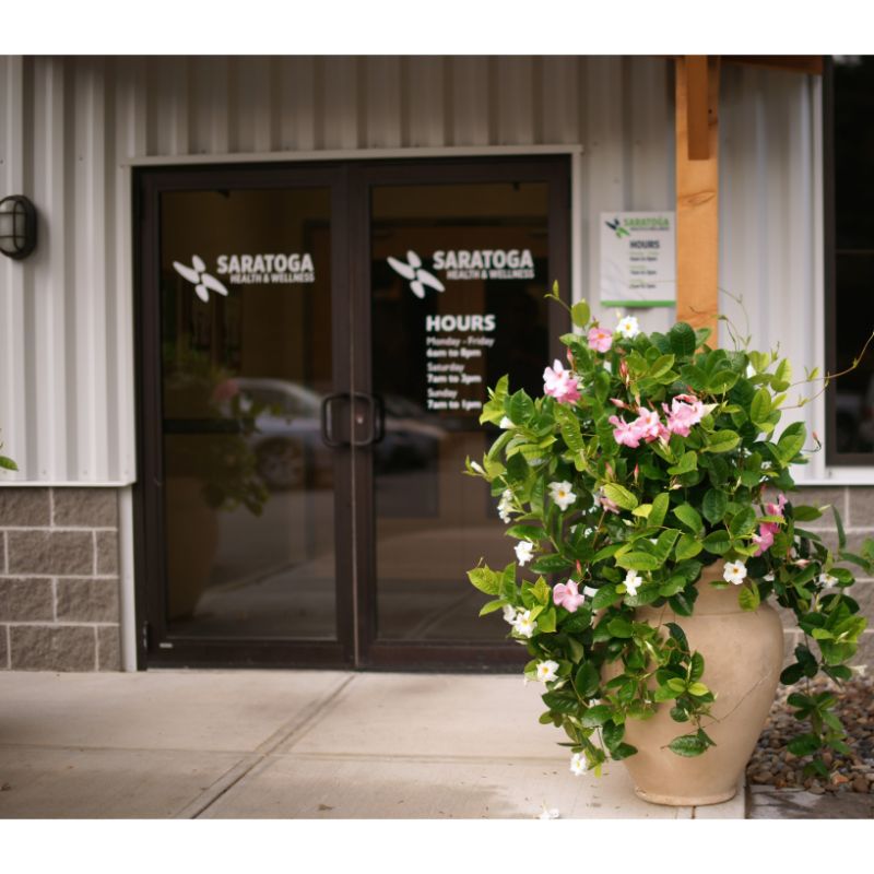 Saratoga Health Wellness Fitness Facility Entrance with Mandevilla Planters and posted hours of operation